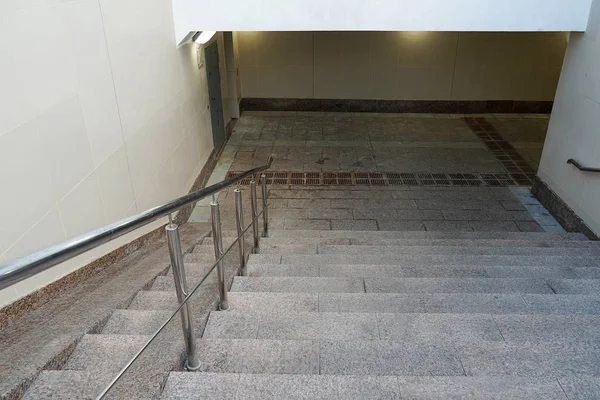 Moderner Eingang zum Fußgängertunnel, der leer nach unten führt. Treppe hinunter in die unterirdische neue Passage. beige Farbe. — Stockfoto