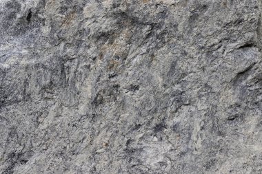 Koyu gri taş yüzey gözeneklidir. Bu yatay bir çimento-c