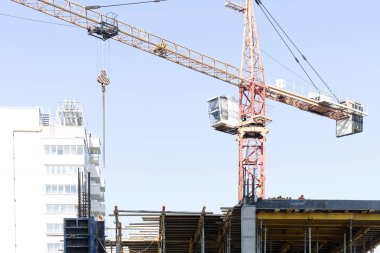 Bir inşaat vinç tesiste sabah çalışır. Yüksek katlı bir binanın yapımında bom vinç. Bir konut binası inşaatı için sapanlar ile Vinç kanca