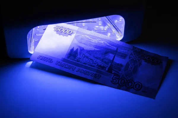 Bir banknotu kızılötesi beş bin ruble kontrol ediyorum. Orijinallik için mavi Rus para Banknotlar, yanlış veya gerçek.