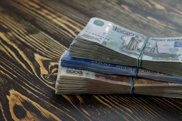 Um pacote de dinheiro russo em diferentes denominações é amarrado com uma faixa elástica. Cinco, dois, mil rublos em notas, uma grande soma de dinheiro . — Fotografia de Stock