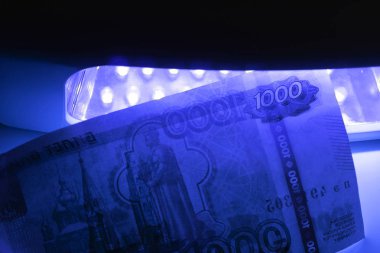 Kızılötesi ışıkta para kontrol ediyorum. Bin ruble yüz değeri ile Rus rubleyanlış veya gerçek kontrol.