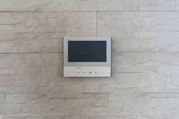 The smart home system is installed in the apartment on the wall. The intercom with video surveillance of the apartment is a modern system with a large display.