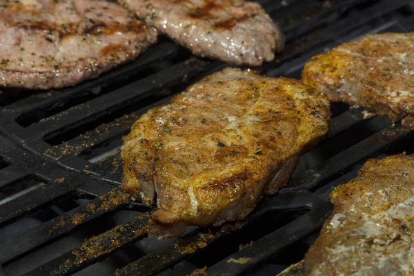 육즙이 많은 고기는 그릴 클로즈업, 몇 조각에 요리된다. 가스 바베큐, 맛있는 구운 고기. — 스톡 사진