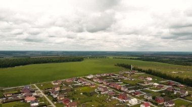Yağmurdan önce özel evlerin üzerinde uçan Swift 'ler güzel bulutlar yeşil çayırlar bir hava helikopterinden çekiliyor.