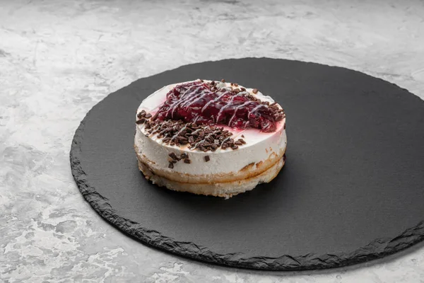 Cake with mousse and jam on a round slate