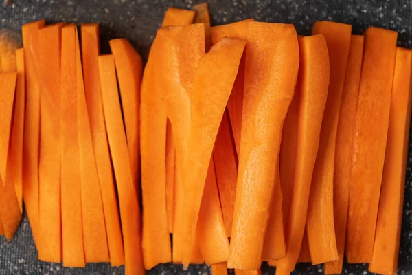 Carrots cut into strips lying on a gray Board top view.