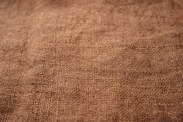Burlap texture at right angles in perspective with a small depth of field and bokeh.