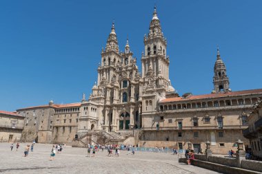 SANTIAGO DE COMPOSTELA, SPAIN - SEPTEMBER 1, 2018: Pilgrims in front of the cathedral of Santiago de Compostela, beautiful building with blue sky on September 1, 2018 in Galicia, Spain clipart