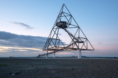 BOTTROP, GERMANY - 29 AĞUSTOS 2020: Tetraeder, Ruhr Metropolis 'in Beckstrasse tepesinde 29 Ağustos 2020' de Bottrop, Almanya 'da gün batımına karşı bir dönüm noktası
