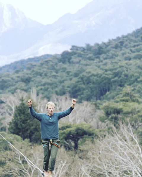 高耸在绳子上 高耸在高山的背景上 大自然的极端运动 在吊带上保持平衡 在高度上保持平衡 — 图库照片