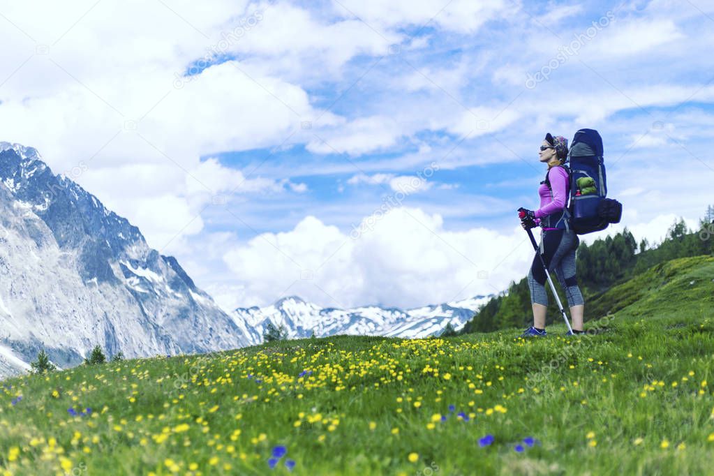 Trek around Mont Blanc. The girl is walking along the trail with a backpack.