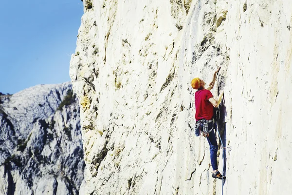 在悬崖上攀登挑战性路线的年轻人仰望 — 图库照片