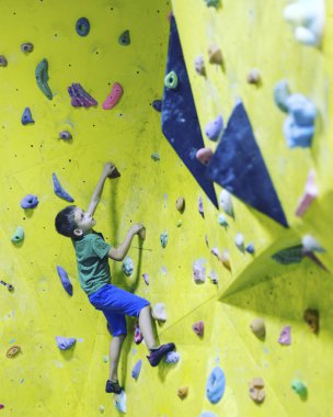 Çocuk bir tırmanma simülatörü tırmanmak için eğitildi.