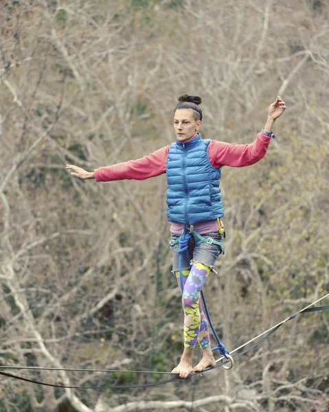 Highliner on a rope. Highline on a background of mountains. Extreme sport on the nature. Balancing on the sling. Equilibrium at altitude.