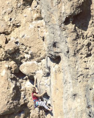 genç kadın dağcı uçurumun yüz.