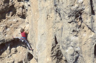 genç kadın dağcı uçurumun yüz.