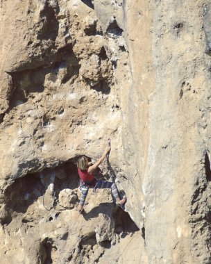 genç kadın dağcı uçurumun yüz.