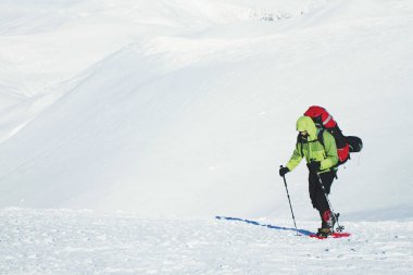 Bir sırt çantası içinde kar ayakkabıları ile dağlarda hiking kış.