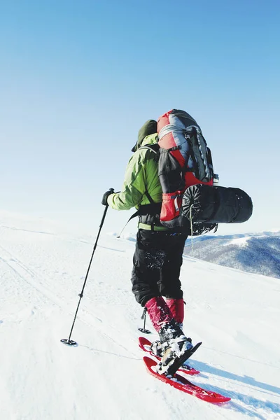 冬のスノーシューでバックパックと山でのハイキング — ストック写真