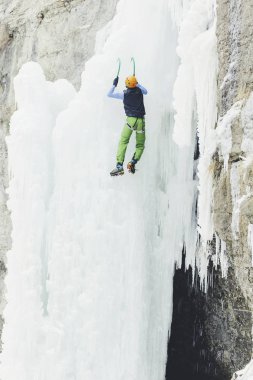 Buz donmuş bir şelale üzerinde tırmanma.