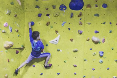 Küçük çocuk kapalı bir kaya duvarı tırmanma. Spor hayatı kavramı.