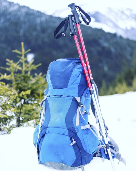Winter hiking in the mountains with a tent in snowshoes.