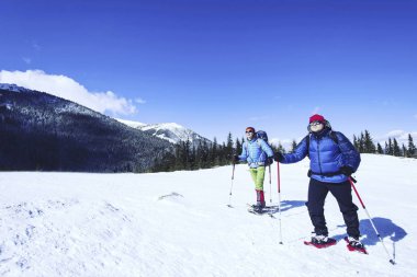 Dağlarda kar ayakkabıları bir sırt çantası ve çadır hiking kış.