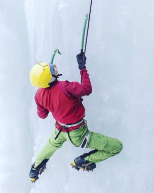 Buz donmuş bir şelale üzerinde tırmanma.