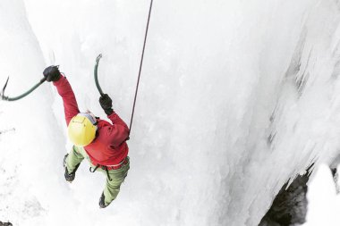 Buz donmuş bir şelale üzerinde tırmanma.