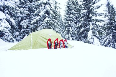 Çadır kış dağlar. Karda dağlarda çadır duruyor. Kar ayakkabılarını çadır vardır.