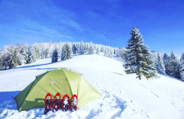 Çadır kış dağlar. Karda dağlarda çadır duruyor. Kar ayakkabılarını çadır vardır.