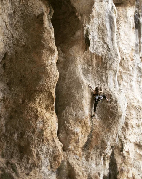 Kız kaya tırmanışçısı zor yol uçurumlarda tırmanıyor. — Stok fotoğraf