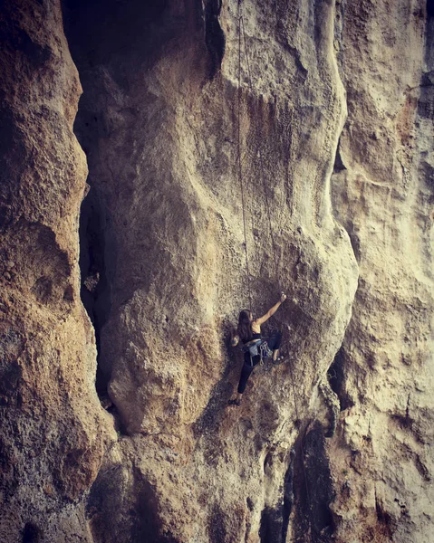 Chica escalador escalada difícil ruta en los acantilados —  Fotos de Stock