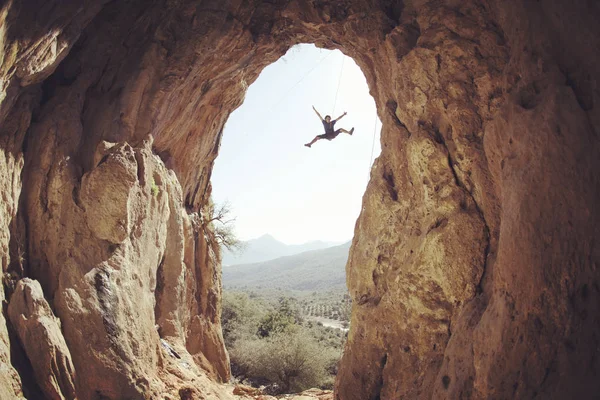 Mannelijke rock klimmer opknoping met één hand op uitdagende route op — Stockfoto