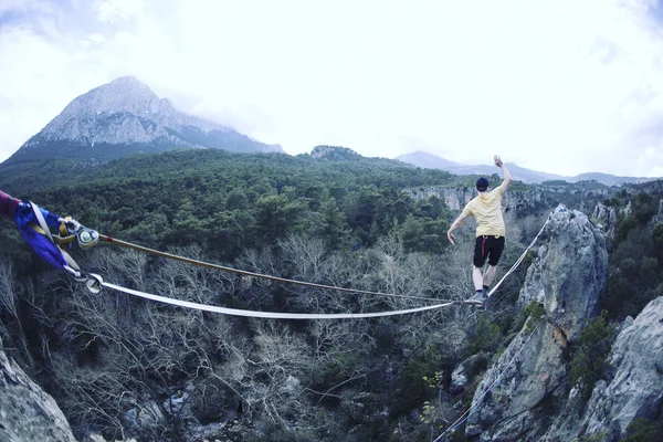 Un hombre camina a lo largo de un cabestrillo estirado . —  Fotos de Stock