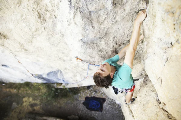 Hombre escalador de rocas. Escalador de rocas sube a una pared rocosa. El hombre hace —  Fotos de Stock