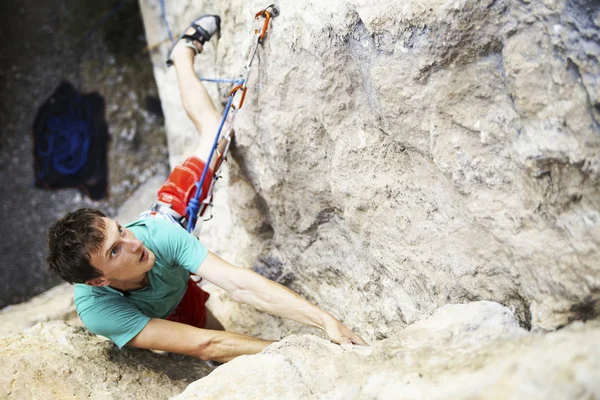 Hombre escalador de rocas. Escalador de rocas sube a una pared rocosa. El hombre hace —  Fotos de Stock