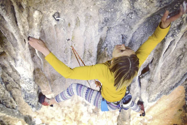 A rapariga sobe a rocha. Fitness na natureza e escalada. T — Fotografia de Stock