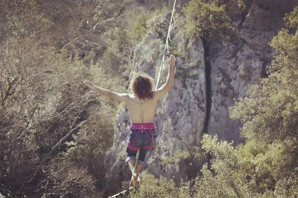 Un uomo sta camminando lungo una fionda allungata. Highline nel monte — Foto Stock