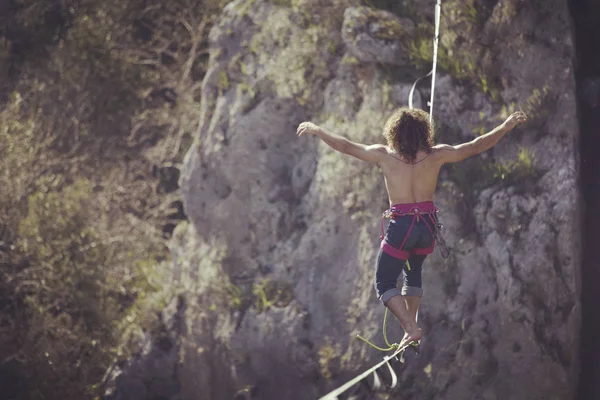 Bir adam gergin bir sapan boyunca yürüyor. Mounta Highline — Stok fotoğraf