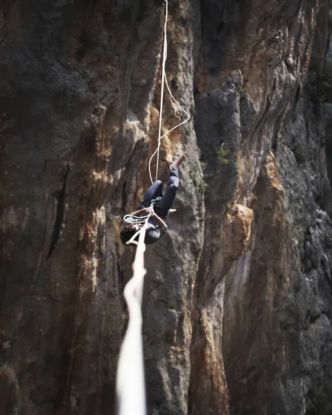 Un hombre camina a lo largo de una honda estirada. Highline en la montaña — Foto de Stock