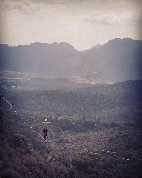Un hombre camina a lo largo de una honda estirada. Highline en la montaña Imagen De Stock