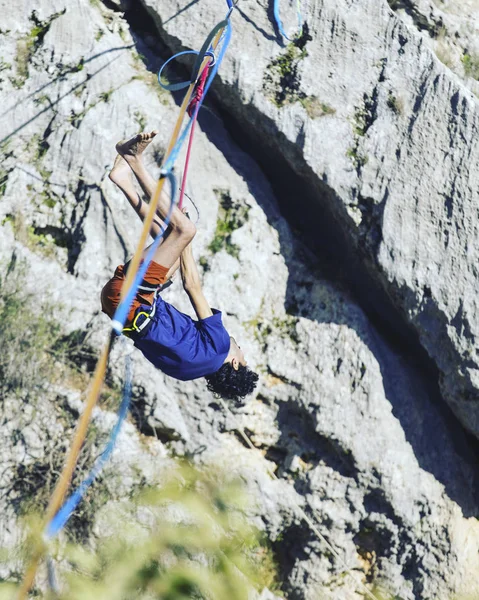 Mężczyzna chodzi wzdłuż rozciągniętego procy. Highline w górach — Zdjęcie stockowe