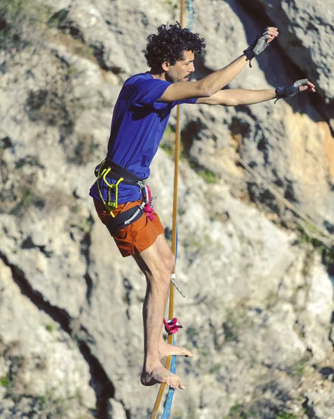 Un hombre camina a lo largo de una honda estirada. Highline en la montaña Fotos De Stock Sin Royalties Gratis