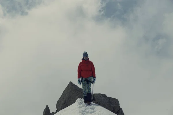 Mujer joven en la cresta de tanta nieve se eleva hacia la cima en th — Foto de Stock