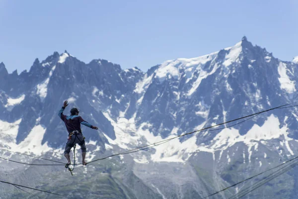 Um homem caminhando ao longo de uma funda contra o pano de fundo dos Alpes. Ch... — Fotografia de Stock