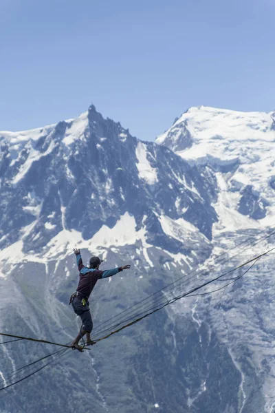 Un uomo che cammina su una fionda sullo sfondo delle Alpi. Ch — Foto Stock