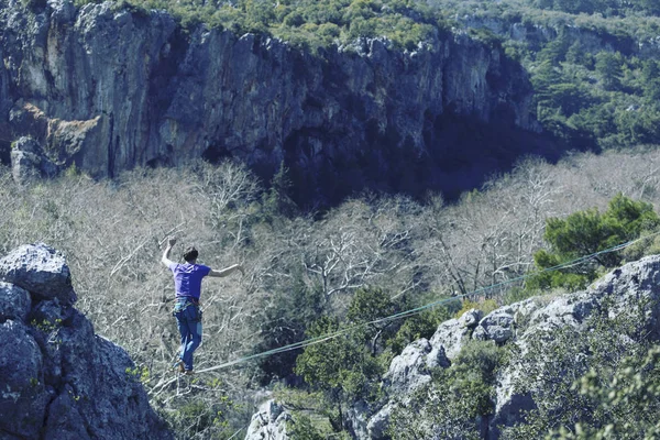 Een man loopt langs een uitgerekte slinger. Highline in de mounta — Stockfoto