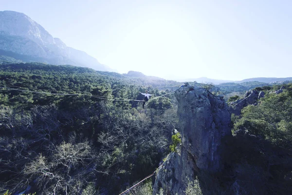 Een man loopt langs een uitgerekte slinger. Highline in de mounta — Stockfoto